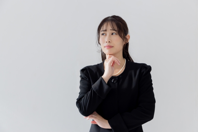 喪服を着て悩む女性